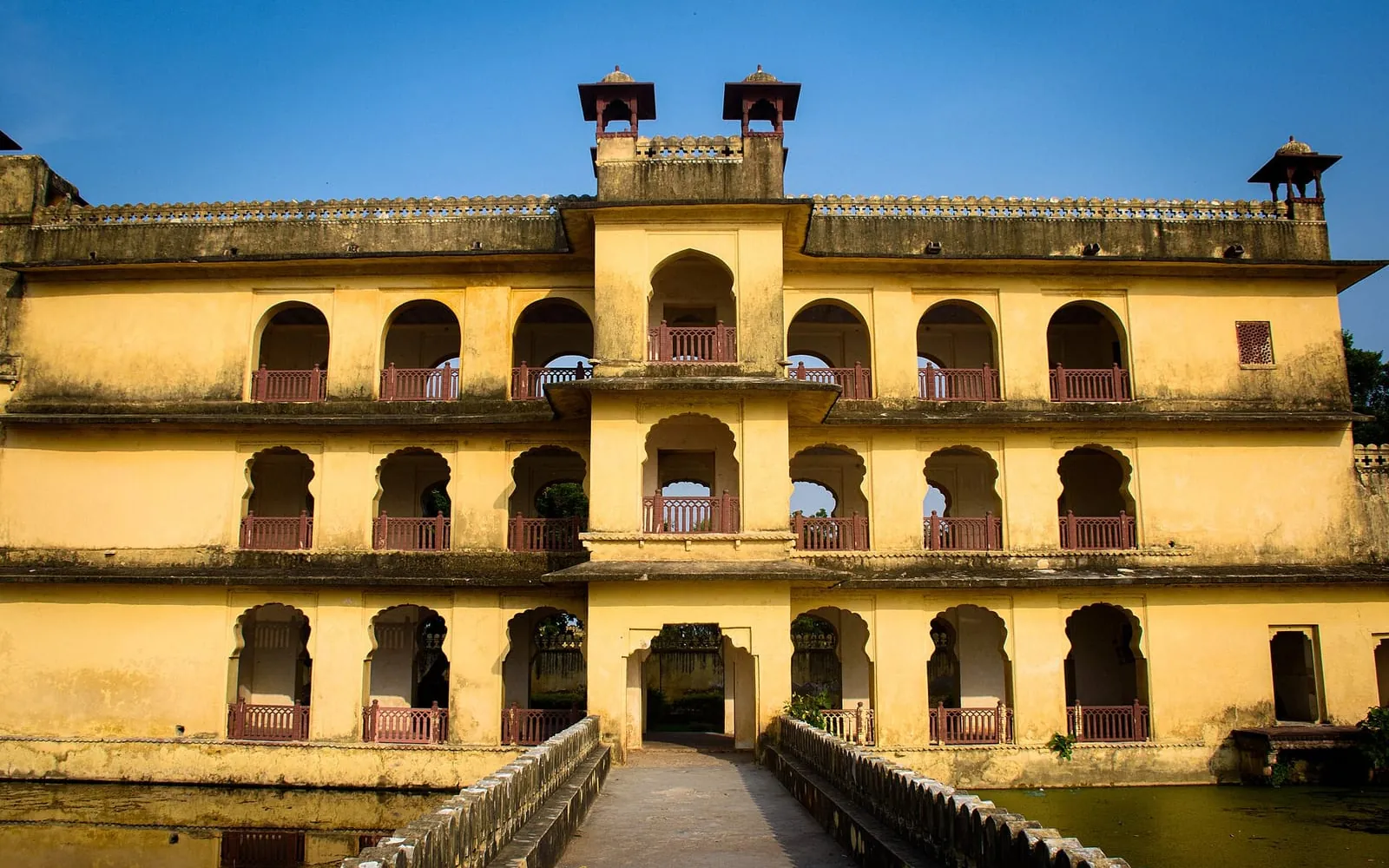 Abheda Mahal in Kota, a yellow palace beside a pond